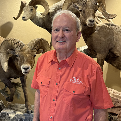 Charlie Kelly in front of several trophy mounts